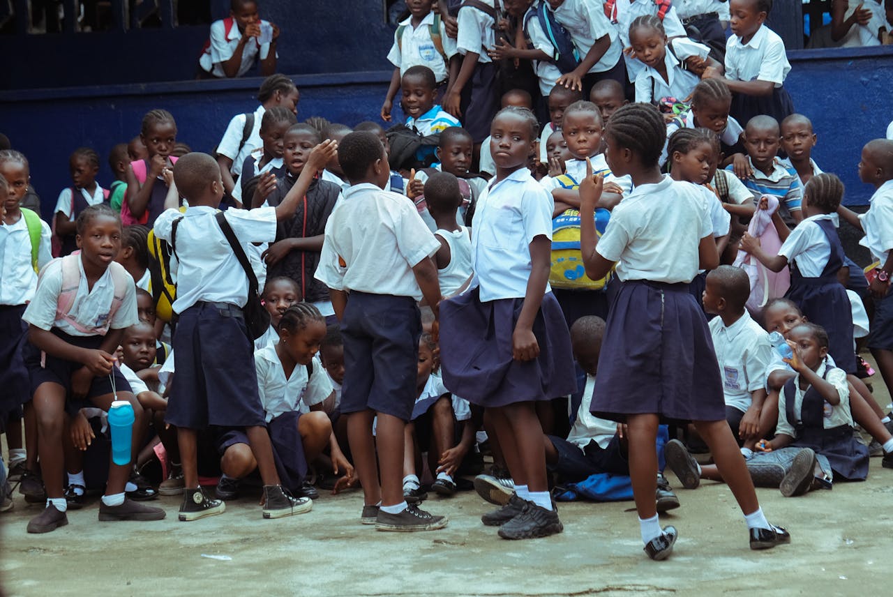 services-01 Group of schoolchildren in uniforms gathering together outside in Monrovia, Liberia.